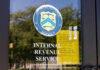 Signage on the window of an IRS office indicating temporary closure due to COVID-19