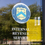 Signage on the window of an IRS office indicating temporary closure due to COVID-19