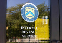 Signage on the window of an IRS office indicating temporary closure due to COVID-19