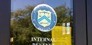 Signage on the window of an IRS office indicating temporary closure due to COVID-19