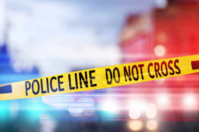 Yellow police tape reading DO NOT CROSS at a crime scene