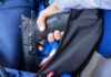 Gun Owners Alarmed by Record Demand A hand holding a handgun partially visible in a backpack