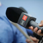 A hand holding a CNN microphone during a news interview