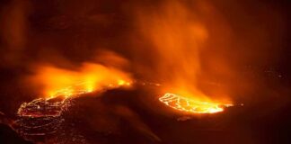 Aerial view of a volcanic eruption with flowing lava at night