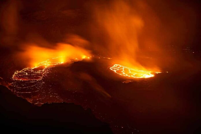 Aerial view of a volcanic eruption with flowing lava at night