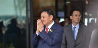 A man in a suit performing a traditional greeting gesture