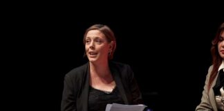 A woman speaking at a panel discussion with a focused expression