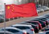 Chinese flag waving in a car park filled with vehicles