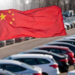 Chinese flag waving in a car park filled with vehicles