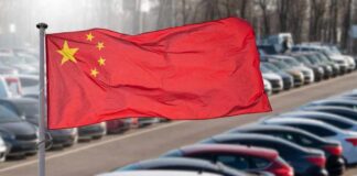 Chinese flag waving in a car park filled with vehicles