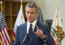 A government official speaking at a podium during a press conference