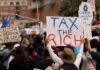 Crowd of protesters holding signs advocating for tax reform