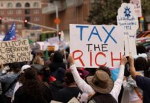 Crowd of protesters holding signs advocating for tax reform
