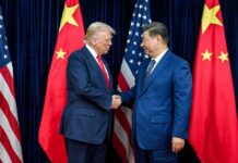 Why Skepticism Shadows the U.S.-China Deal Two political leaders shaking hands in front of national flags