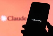 Trillion Tease Sparks Washington Fury A hand holding a smartphone displaying the word 'ANTHROPIC' against a blurred background