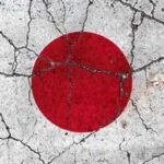 Japanese flag with a red circle on a white background waving against a blue sky
