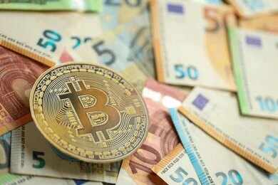 Bitcoin coin on scattered euro banknotes