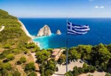 Offshore Hubs: Europe’s Dark New Bet Greek flag overlooking a coastal cliff and turquoise sea