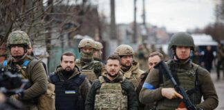 A group of military personnel in tactical gear walking through an urban area
