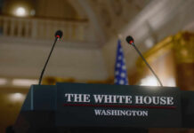 Explosive Drone Plot Targeted White House Press podium with microphones and an American flag in the background