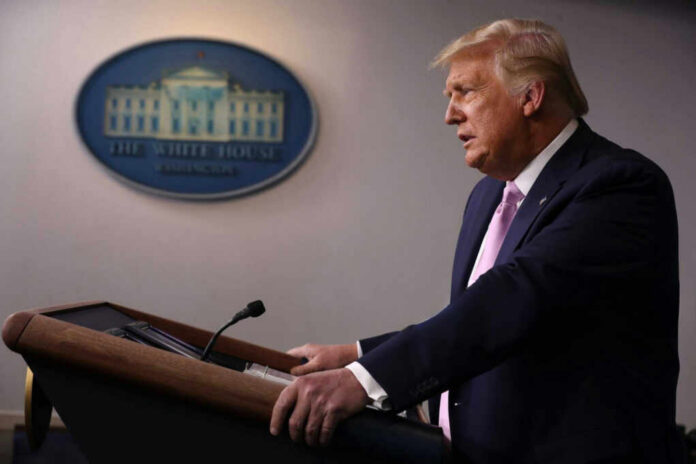 A government official speaking at a podium during a press conference at the White House