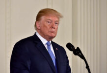 Trump Walks Out After Heated NBC Clash A political figure standing at a microphone with a serious expression