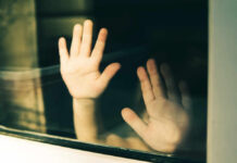 Grooming Files Reopened — Decade of Failure? Child's hands pressed against a window, creating a reflective image