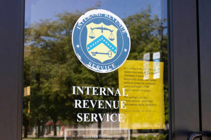 Signage on the window of an IRS office indicating temporary closure due to COVID-19