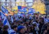 Crowd waving Israeli and American flags at a city rally
