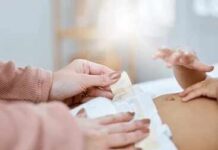 Chemical Alarm Hits Top Diaper Brands Caregiver changing a baby's diaper