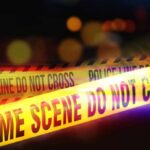 New Footage Challenges Earlier Claims Yellow police tape marking a crime scene with blurred lights in the background
