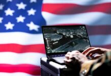 Laptop with surveillance software against a blurred American flag
