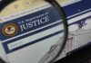 DOJ Targets China-Linked Billionaire Close-up view of the U.S. Department of Justice website through a magnifying glass