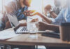 The Hidden Catch In Microsoft’s New AI Group of professionals engaged in a discussion around a laptop at a table