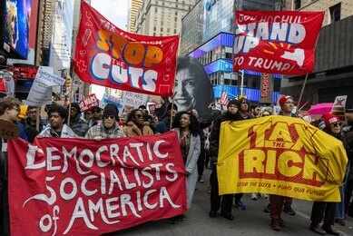 2762026385 Protesters march in a city with large red banners