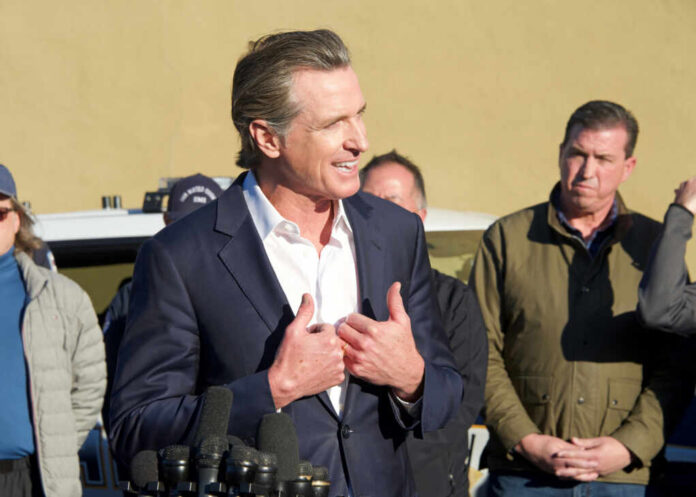 shutterstock2255383531jpg Politician speaking at a press conference with a group of people in the background