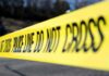 Gun Ban Failed To Stop Killer Yellow police tape stretched across an outdoor scene
