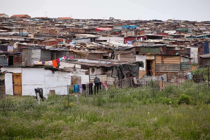 shutterstock_1755814349 Informal settlement of corrugated metal shacks with laundry hanging