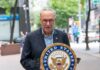 man speaking at a podium with a United States Senate seal