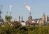 Industrial refinery with smoke stacks and visible flames