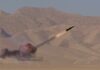 Iran Claims Strike On Jordan Base A missile launching into the sky with smoke and flames in a desert setting