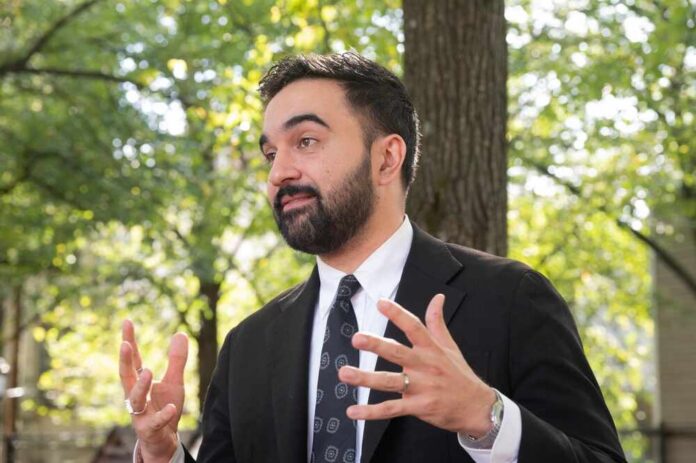 Mayoral,Candidate,Zohran,Mamdani,Attends,Canvassing,Ahead,Of,Vote,In Man in a suit gesturing while speaking outdoors