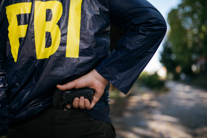 FBI agent gripping handgun near waistband outdoors