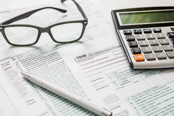 Tax forms with calculator, glasses, and pen