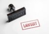 Rubber stamp with red lawsuit imprint on white paper
