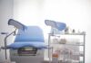 Gynecological exam chair with blue padding in a clinic room