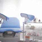 Gynecological exam chair with blue padding in a clinic room