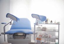 Gynecological exam chair with blue padding in a clinic room