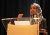 Woman in hijab speaking at a podium