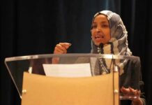 Woman in hijab speaking at a podium